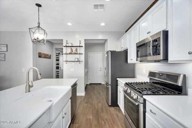 kitchen with visible vents, light countertops, appliances with stainless steel finishes, dark wood-style floors, and white cabinetry