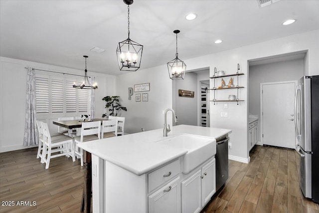 kitchen featuring a sink, wood finished floors, recessed lighting, stainless steel appliances, and an inviting chandelier