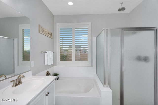 full bath featuring vanity, a shower stall, and a garden tub