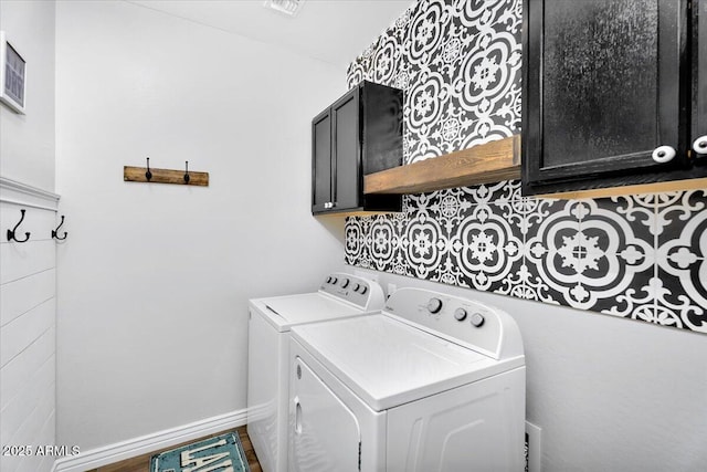 washroom featuring washer and dryer, baseboards, and cabinet space