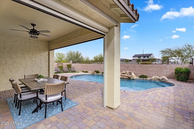 view of swimming pool with a fenced in pool, outdoor dining area, a fenced backyard, a ceiling fan, and a patio