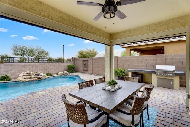 view of pool featuring an outdoor kitchen, a patio area, a fenced backyard, and a grill