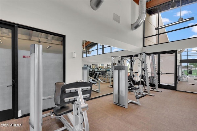 gym with a high ceiling and visible vents