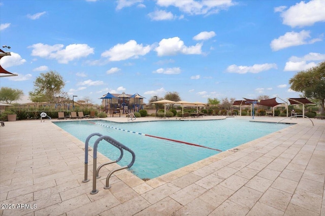 pool featuring playground community, a patio area, and fence