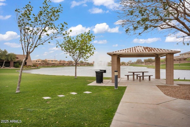 view of community with a gazebo, a yard, and a water view