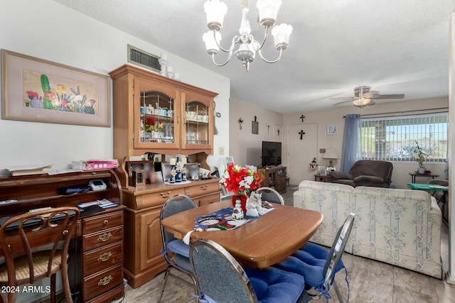 dining area featuring ceiling fan with notable chandelier and a textured ceiling