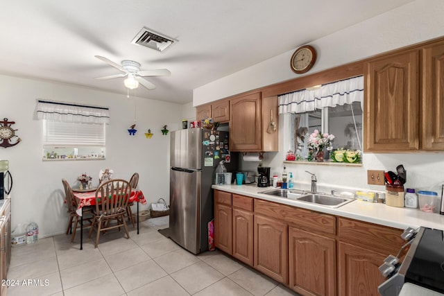 kitchen with stainless steel refrigerator, ceiling fan, sink, light tile patterned flooring, and range