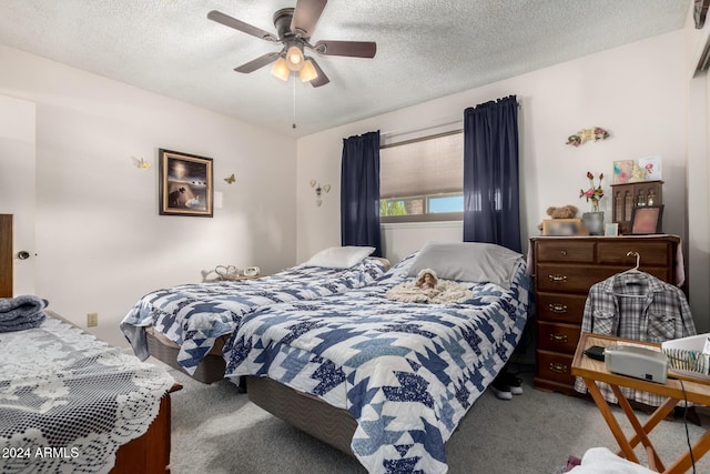 carpeted bedroom with a textured ceiling and ceiling fan