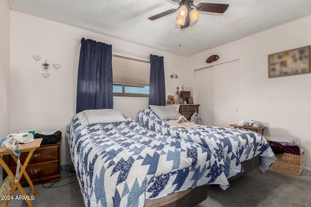 carpeted bedroom with ceiling fan, a textured ceiling, and a closet