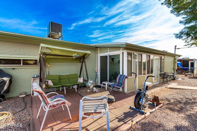 rear view of property featuring central AC and a sunroom