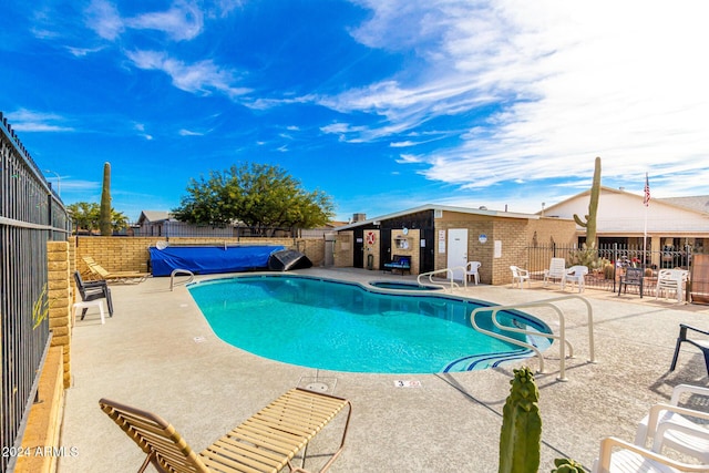 view of swimming pool with a patio area and a community hot tub