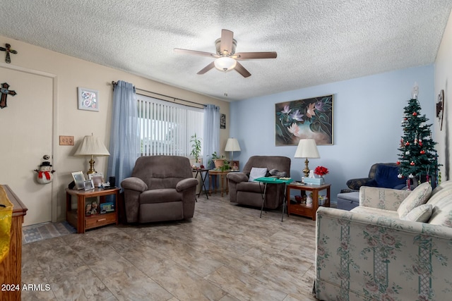 living room with ceiling fan and a textured ceiling