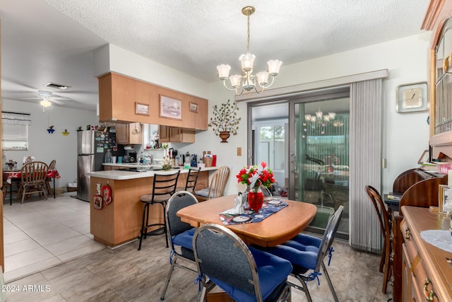 dining room featuring a textured ceiling and ceiling fan with notable chandelier