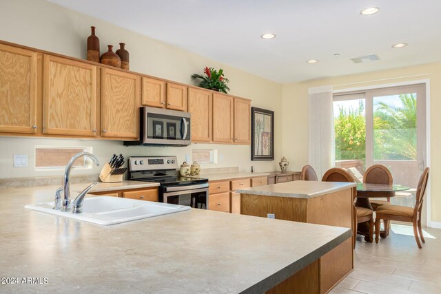 kitchen featuring a kitchen island, stainless steel appliances, and sink