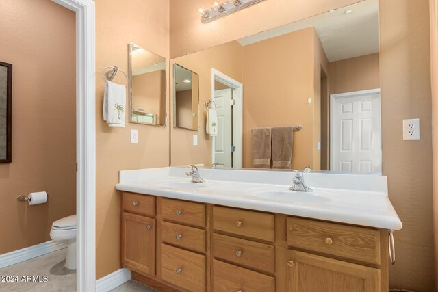 bathroom featuring tile patterned flooring, vanity, and toilet