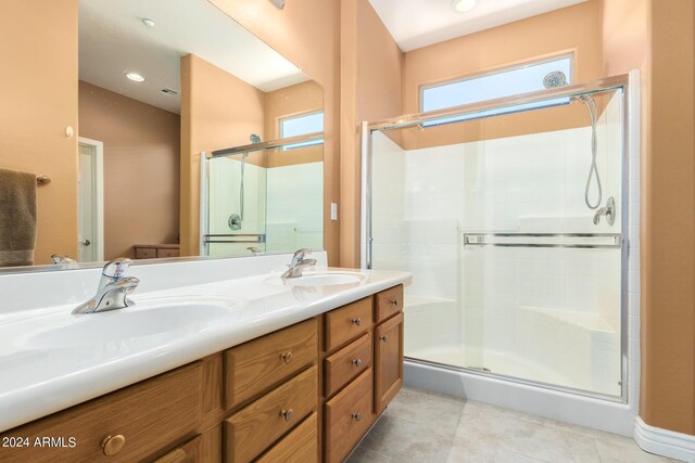 bathroom featuring vanity, a wealth of natural light, walk in shower, and tile patterned flooring