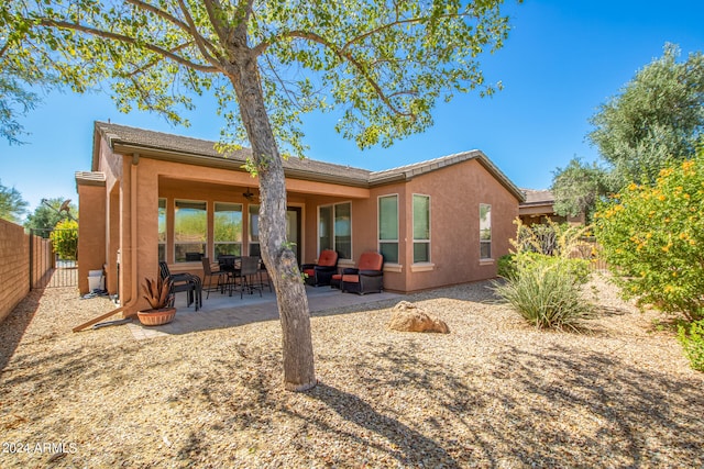 back of house with an outdoor living space and a patio