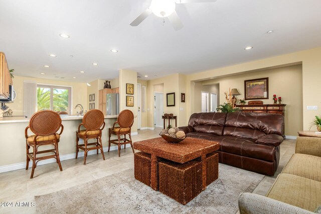 tiled living room with sink and ceiling fan