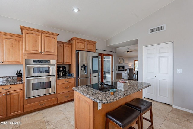 15746 E Sycamore Dr, Fountain Hills, AZ 85268 - kitchen featuring a breakfast bar, vaulted ceiling, a kitchen island, visible vents, and stainless steel appliances
