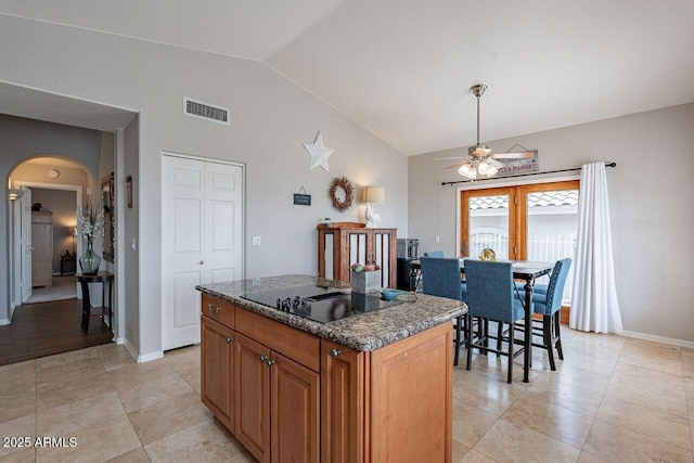 15746 E Sycamore Dr, Fountain Hills, AZ 85268 - kitchen with vaulted ceiling, black electric stovetop, a center island, a ceiling fan, and arched walkways