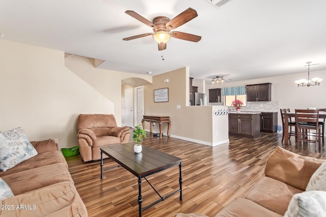 living room featuring hardwood / wood-style flooring and ceiling fan with notable chandelier