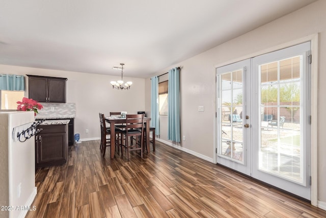 dining room with dark hardwood / wood-style flooring, french doors, and a chandelier