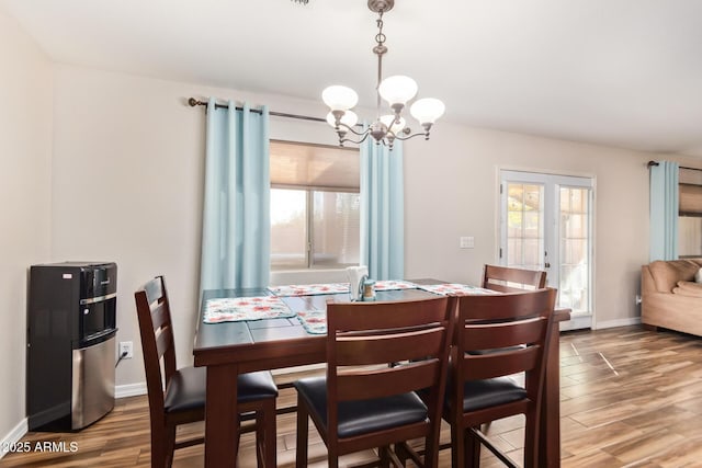 dining space with a notable chandelier, hardwood / wood-style flooring, and french doors