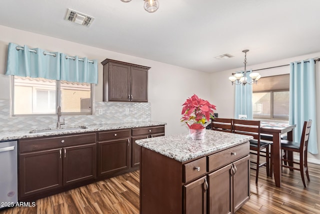 kitchen with pendant lighting, tasteful backsplash, sink, dark hardwood / wood-style flooring, and stainless steel dishwasher