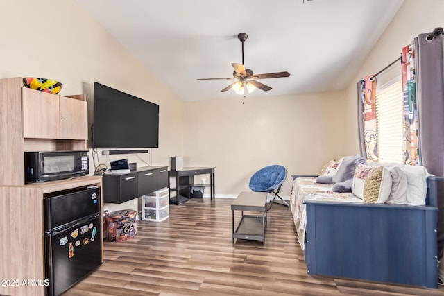 living room featuring hardwood / wood-style floors, vaulted ceiling, and ceiling fan