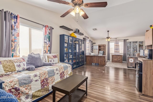 living room with vaulted ceiling, hardwood / wood-style floors, and ceiling fan