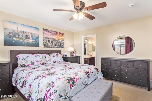 bedroom with ceiling fan, ensuite bathroom, sink, and light carpet