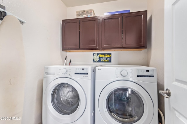 washroom with cabinets and washer and dryer