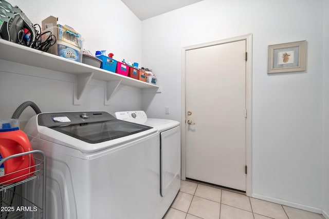 washroom with light tile patterned floors and washing machine and dryer