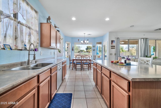 kitchen featuring sink, pendant lighting, a chandelier, a kitchen island, and light tile patterned flooring