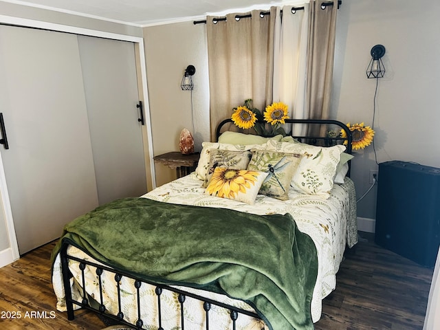 bedroom featuring a closet, crown molding, and wood finished floors