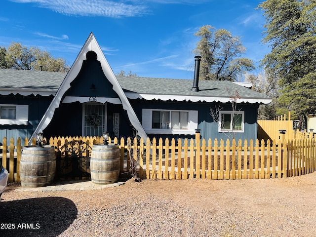 exterior space with a shingled roof and fence