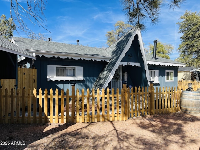 view of front facade featuring fence and a shingled roof