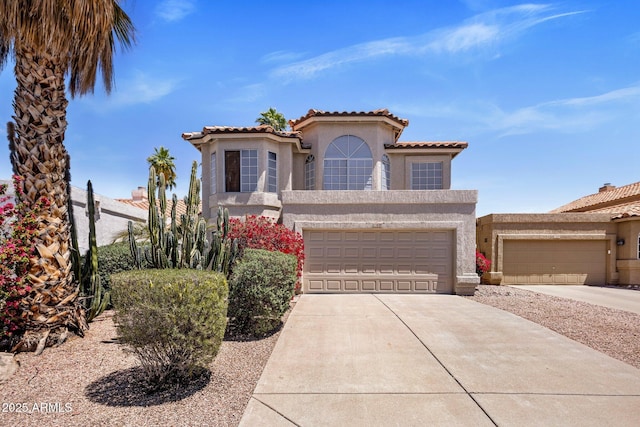 mediterranean / spanish home with stucco siding, concrete driveway, a tile roof, and an attached garage