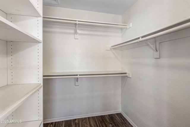 spacious closet with dark wood finished floors