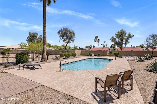 community pool with a patio and a fenced backyard