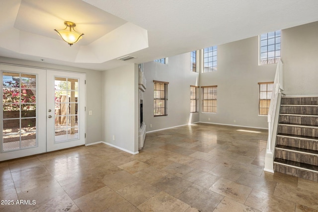 entrance foyer with baseboards, plenty of natural light, and french doors
