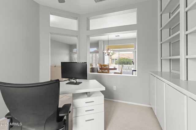 carpeted home office with an inviting chandelier