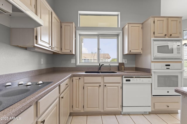 kitchen with white appliances, sink, and light tile patterned floors