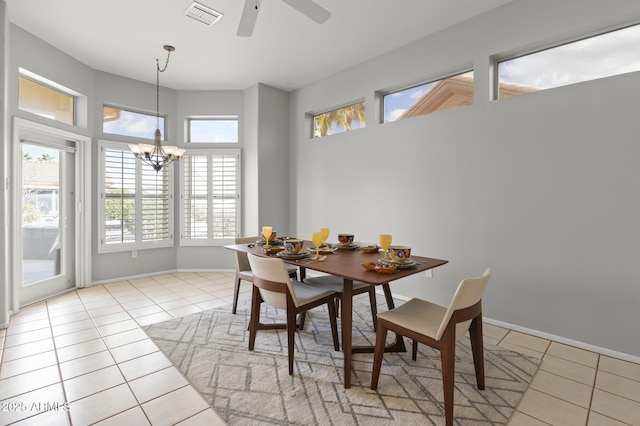 tiled dining area featuring ceiling fan with notable chandelier