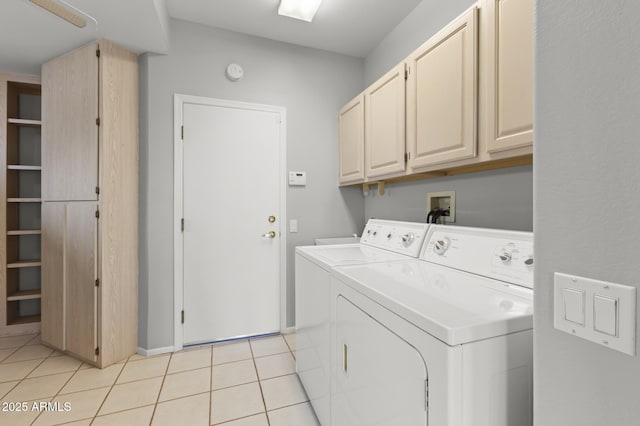 laundry room with separate washer and dryer, light tile patterned floors, and cabinets