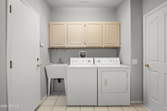 washroom with cabinets, washing machine and dryer, and light tile patterned flooring