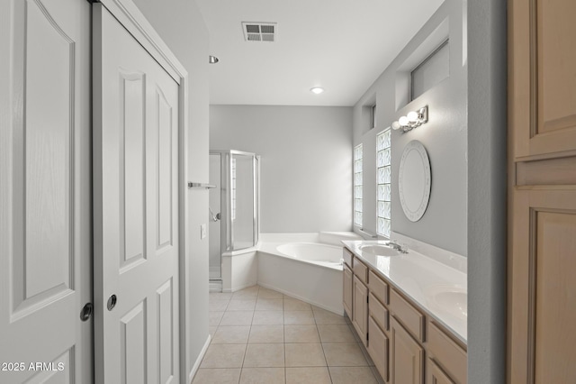 bathroom featuring tile patterned flooring, vanity, and shower with separate bathtub