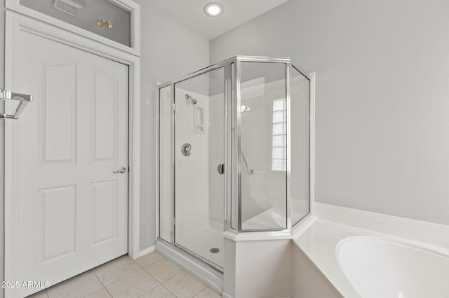 bathroom featuring tile patterned flooring and separate shower and tub