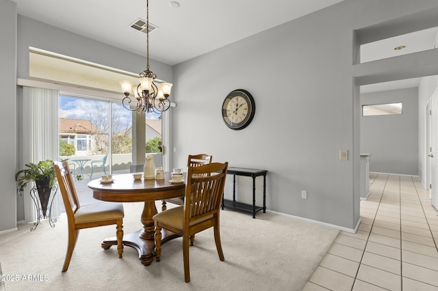 tiled dining room featuring an inviting chandelier