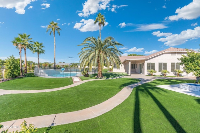 view of community with a swimming pool and a lawn